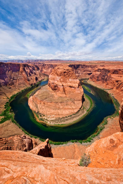 Horseshoe Bend on the Colorado River The Colorado River provides some incredible natural vistas along its length.  One of the more unusual views is at Horseshoe Bend.  The name was inspired by its unusual shape, a horseshoe-shaped meander of the river.  Horseshoe Bend, located about four miles southwest of Page, Arizona, USA within the Glen Canyon National Recreation Area has become a very popular tourist attraction. jeff goulden mojave desert stock pictures, royalty-free photos & images