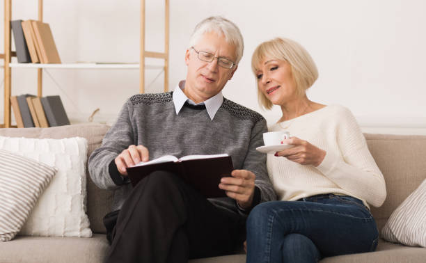 istock Elderly couple spending time together and reading book 1160976542