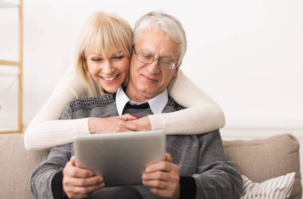 istock Elderly couple using digital tablet in living room 1160976604
