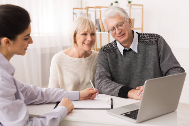 istock Older couple considering new home purchase looking at laptop 1160976717