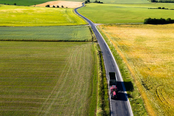 istock Tractor with trailer on rural road, aerial view 1160980925