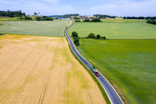 istock Tractor with trailer on rural road, aerial view 1160982371