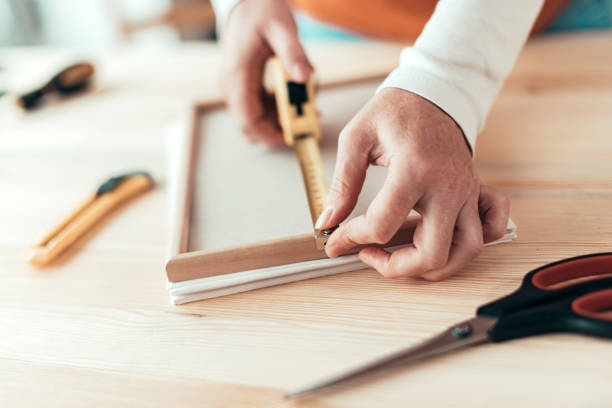 istock Female carpenter tape measuring picture frame 1160982548