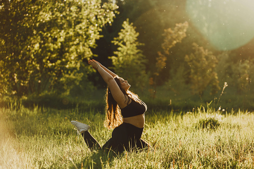 Chica de talla plus haciendo yoga en la naturaleza. photo