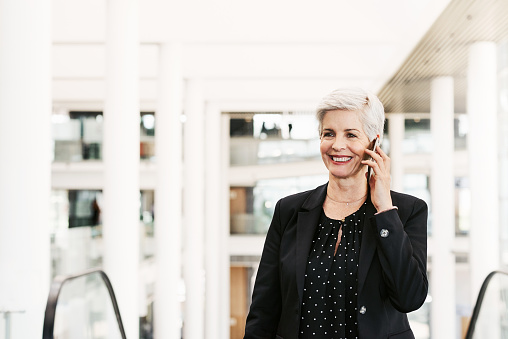 Shot of a mature businesswoman using a smartphone in a convention centre
