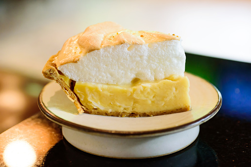 Piece of coconut meringue pie on white dish