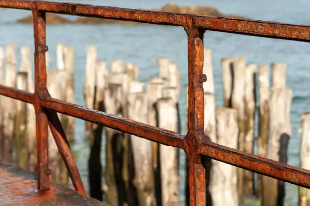 Photo of old rusty fence of Saint Malo with breakwater