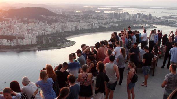 rio de janeiro skyline, seashore and people scene from sugarloaf mountain observation area in brazil rio de janeiro skyline, seashore and people scene from sugarloaf mountain observation area in brazil rio de janeiro skyline, seashore and people scene from - rio de janeiro guanabara bay urban scene cityscape photos et images de collection