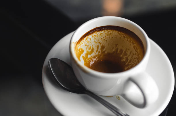 istock close up modern hot black coffee the espresso on dark background with coffee bubble foam pattern and texture in empty white cup looking and feel so delicious on glasses table in coffee shop. 1160992889
