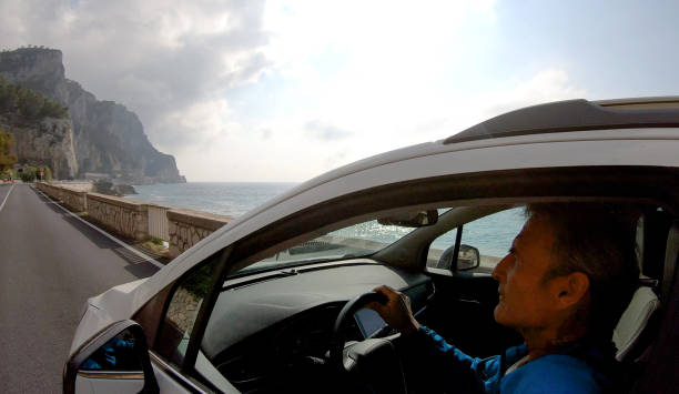 istock Mature man drives car along the seaside 1160996307