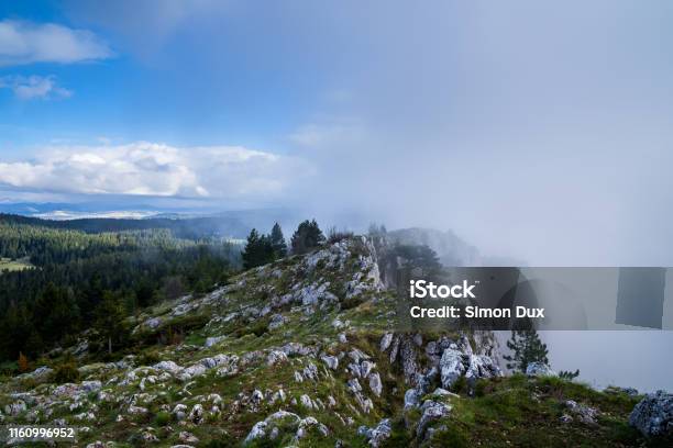 Montenegro Weather Contrast Of Blue Sky Versus Foggy Rain Clouds Coming And Changing Fast On Summit Of Mount Curevac After Adventurous Hike Through Durmitor National Park Highlands To The Edge Of Tara River Canyon Stock Photo - Download Image Now
