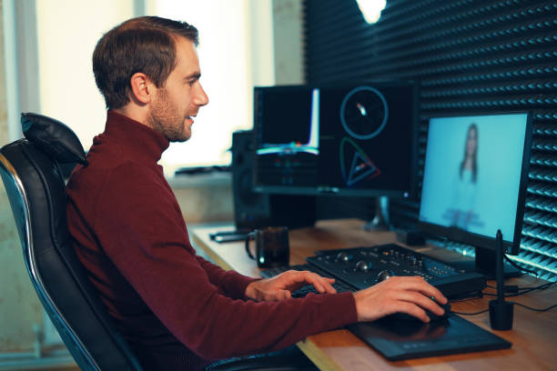 istock Male Videographer Edits and Cuts Footage and Sound on His Personal Computer 1160999834