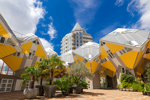 Rotterdam, The Netherlands - july 2019: Public space under the beautiful yellow cube houses with lush potted plants garden on a sunny afternoon