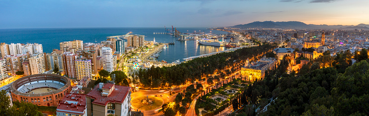 Panorama view of port and centre of Malaga City at dusk, Andalucía, Spain