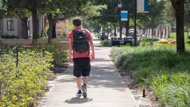 若い学生の背中が急いで歩道を歩く - campus university walking school ストックフォトと画像