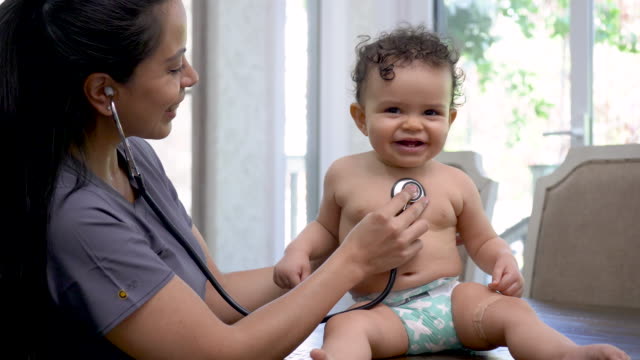 Female doctor check's baby's heart rate