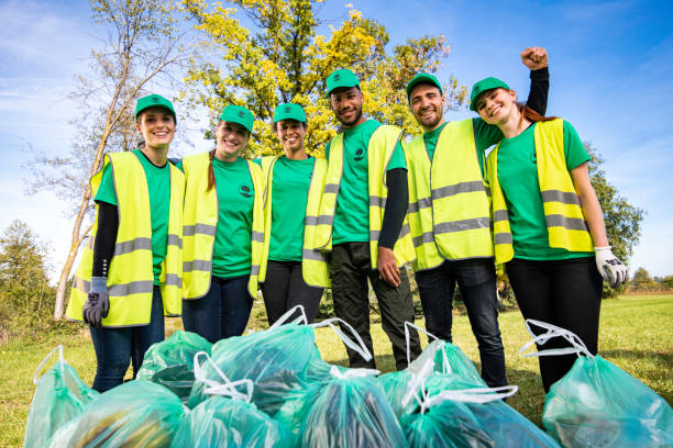 istock Park clean-up volunteers posing with trash bags 1161008151