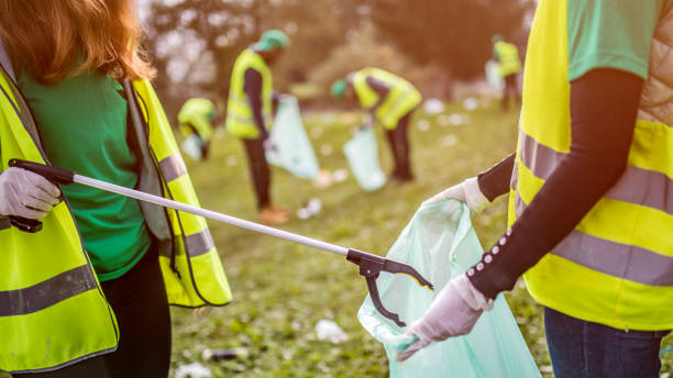 istock Volunteers picking up trash in a park 1161008223