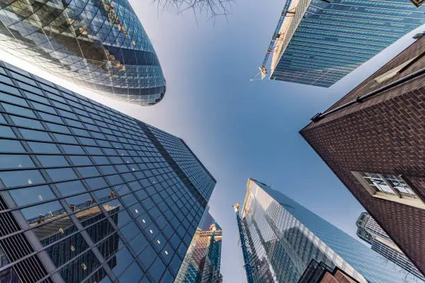 Highly detailed abstract wide angle view up towards the sky in the financial district of London City and its ultra modern contemporary buildings with unique architecture. Shot on Canon EOS R full frame with 14mm wide angle lens. Image is ideal for background.