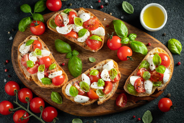 istock Bruschetta with tomatoes, mozzarella cheese and basil on a cutting board. Traditional italian appetizer or snack, antipasto. Top view with copy space. Flat lay 1161010703