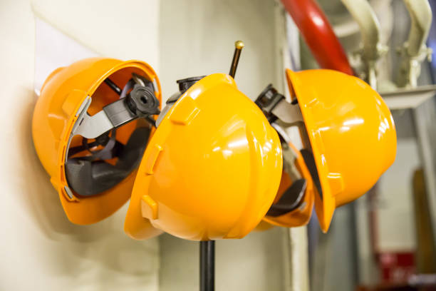 istock Yellow hard hat safety wear helmet hanging on coat rack at construction site 1161013211