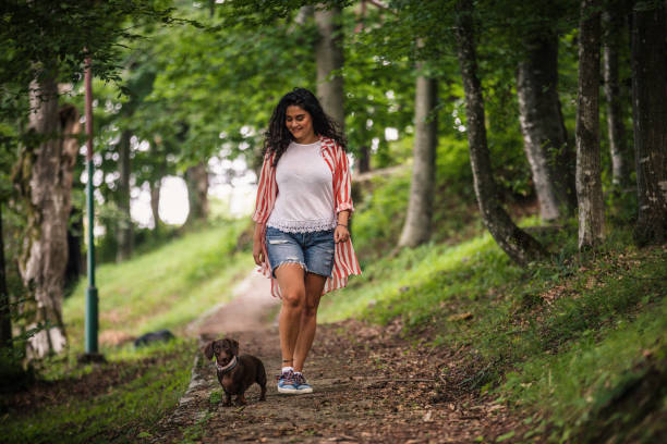istock Happy woman and her dog taking a walk 1161020281