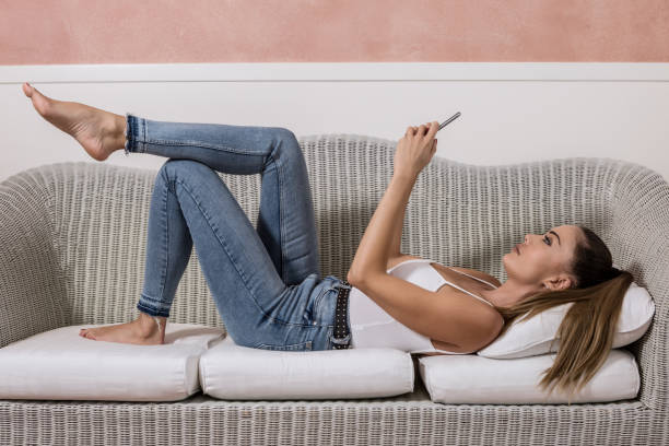 istock Businesswoman using smartphone on couch 1161020722