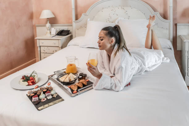 istock Barefoot woman enjoying breakfast on bed 1161020833