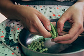 Girl cleans the organic green pea
