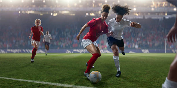 Professional Women Soccer Player Dribbling Ball Past Rival During Match stock photo