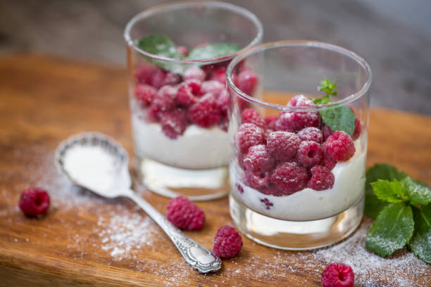 istock Fresh raspberries with cream in glasses, sweet dessert. Selective soft focus. 1161024136