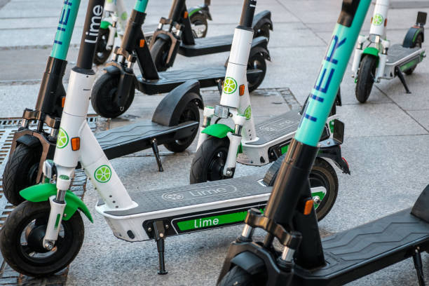 Electric scooter , escooter or e-scooter of the ride sharing company LIME and TIER on sidewalk Berlin, Germany - June, 2019: Electric scooter , escooter or e-scooter of the ride sharing company LIME and TIER on sidewalk in Berlin, Germany lime scooter stock pictures, royalty-free photos & images