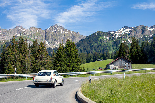 A car driving through the Italian Alps during summertime.