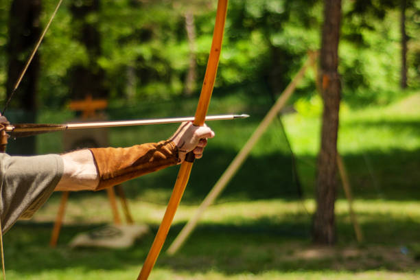 男の中世の射手の手は矢で彼の弓を保持し、ターゲットを目指して - warrior men horizontal selective focus ストックフォトと画像