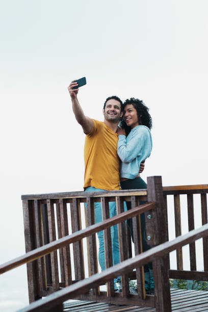 istock Couple embraced on a balcony after trekking, taking a selfie 1161038431