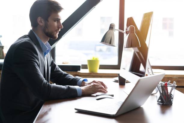 istock Happy young businessman using laptop at his office desk. 1161040274