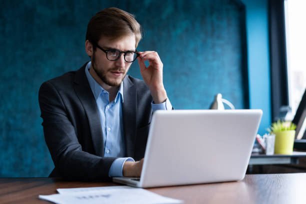 istock Happy young businessman using laptop at his office desk. 1161040360