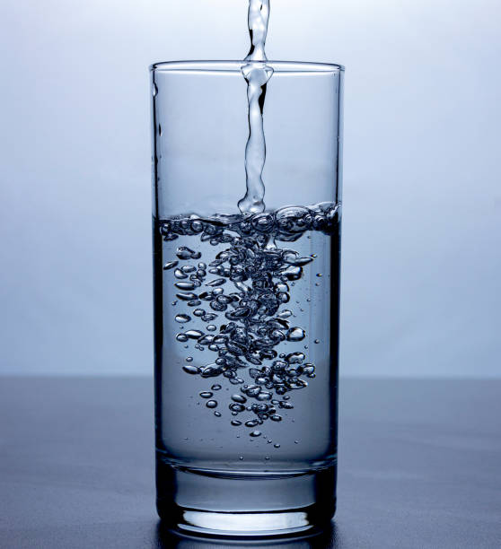 istock Transparent liquid (water) splash of microwaves inside a glass on a white background. 1161040946