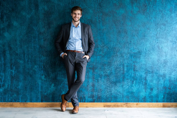 улыбающийся бизнесмен полнометражный портрет - hip expressing positivity full blue стоковые фото и изображения
