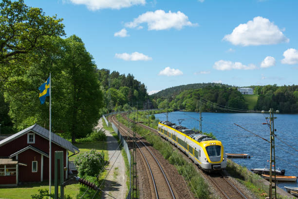 Train on the west Coast with Lake Aspen in the background Tåg passerar genom Jonsered utanför Göteborg västra götaland county stock pictures, royalty-free photos & images