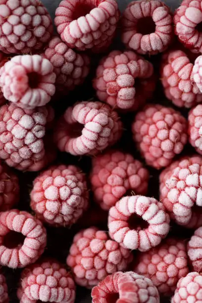 Frozen raspberries in hoarfrost close up background overhead view