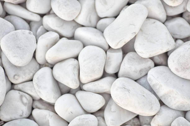 Naturally polished white rock pebbles background. white stones in design