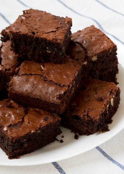 istock Freshly baked chocolate brownies on a white plate, side view. Closeup. 1161048921