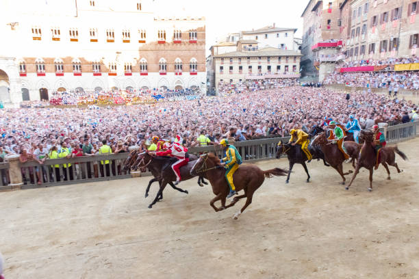 2019 팔리오 디 시에나(palio di siena)가 이탈리아 토스카나시에 있는 시에나 시에서 열린 2019 팔리오 디 시에나의 첫 번째 랩에서 경쟁하는 말. - palio horse italy jockey 뉴스 사진 이미지