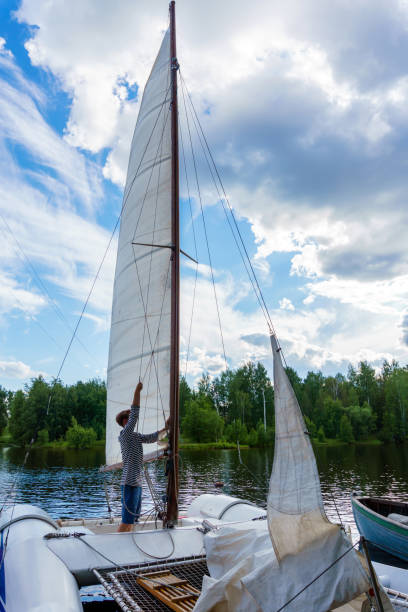 istock young sailor raises sail on a small sailing catamaran 1161057759