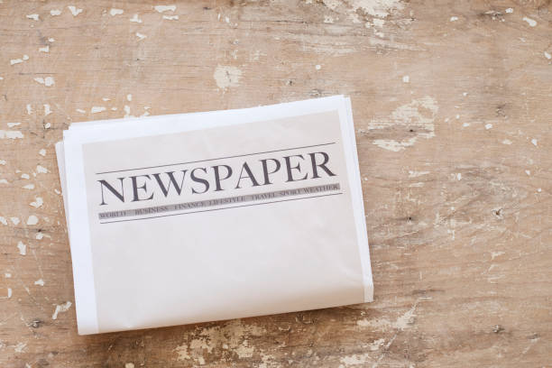 istock Newspaper and coffee on wooden background 1161060944