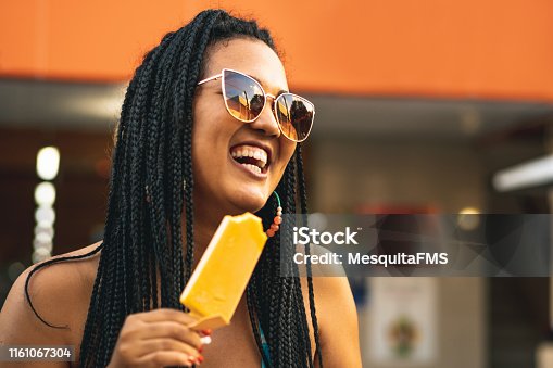 istock Afro woman eating geladinho or chupchup 1161067304