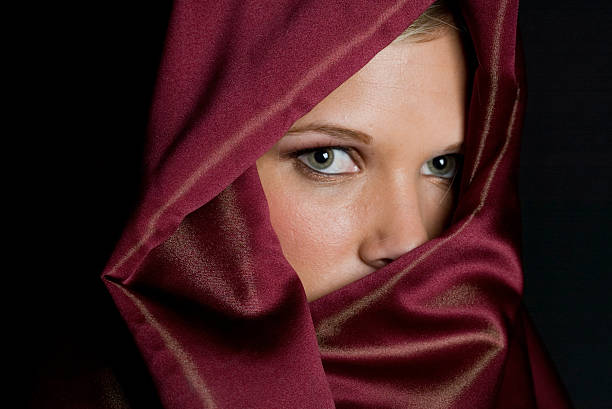 Mystery woman in red veil with beautiful green eyes stock photo