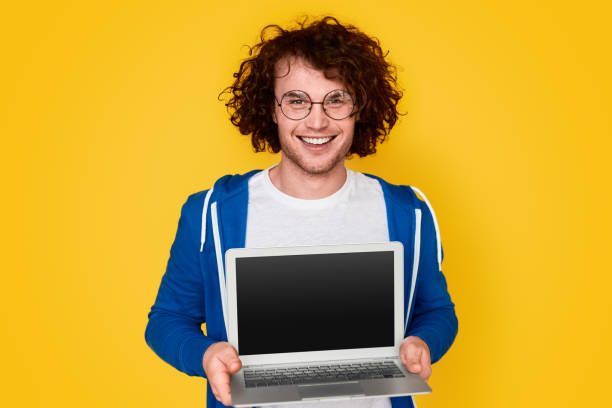istock Cheerful nerd showing blank laptop 1161070364