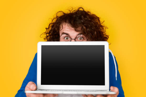 istock Funny nerdy guy showing blank laptop 1161070374